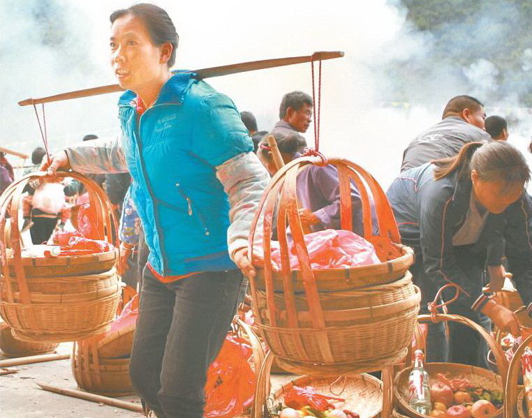 11月25日上午,許多村民挑著食品來(lái)參加祭祀活動(dòng),興奮不已。